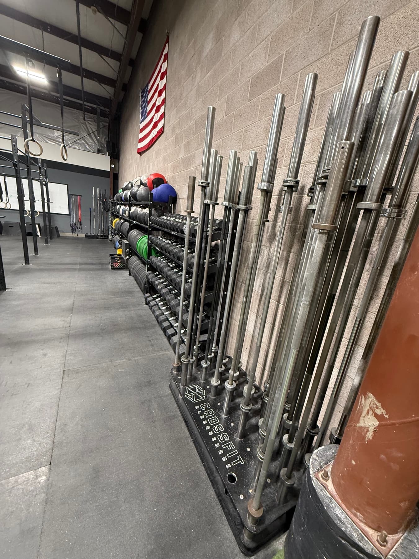 Inside CrossFit Albuquerque: the gym floor, the rig, and rowers under the flag